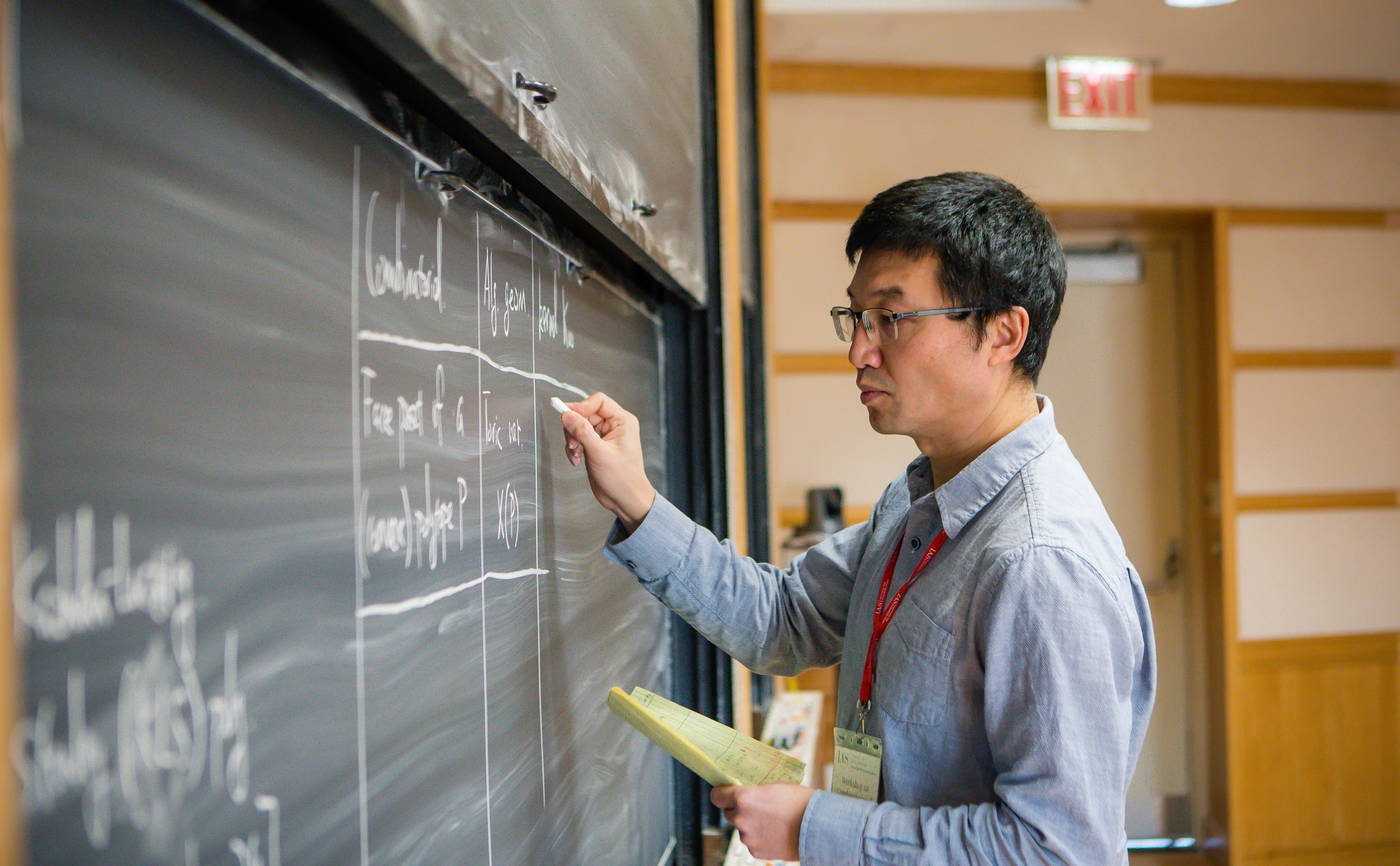 Botong Wang writing mathematics on a chalkboard